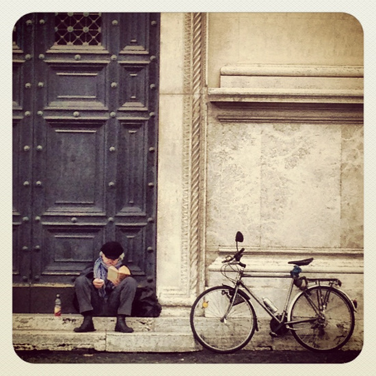 Bike rider reading in Rome (photo by Tui Snider)